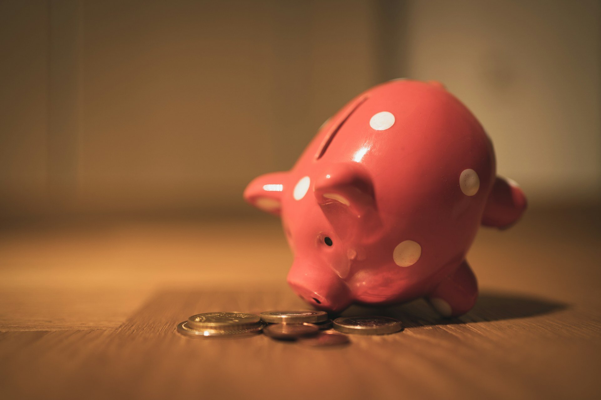 Auf dem Bild sieht man ein umgekipptes Sparschwein mit einem paar Geldmünzen | © Andre Taissin / Unsplash