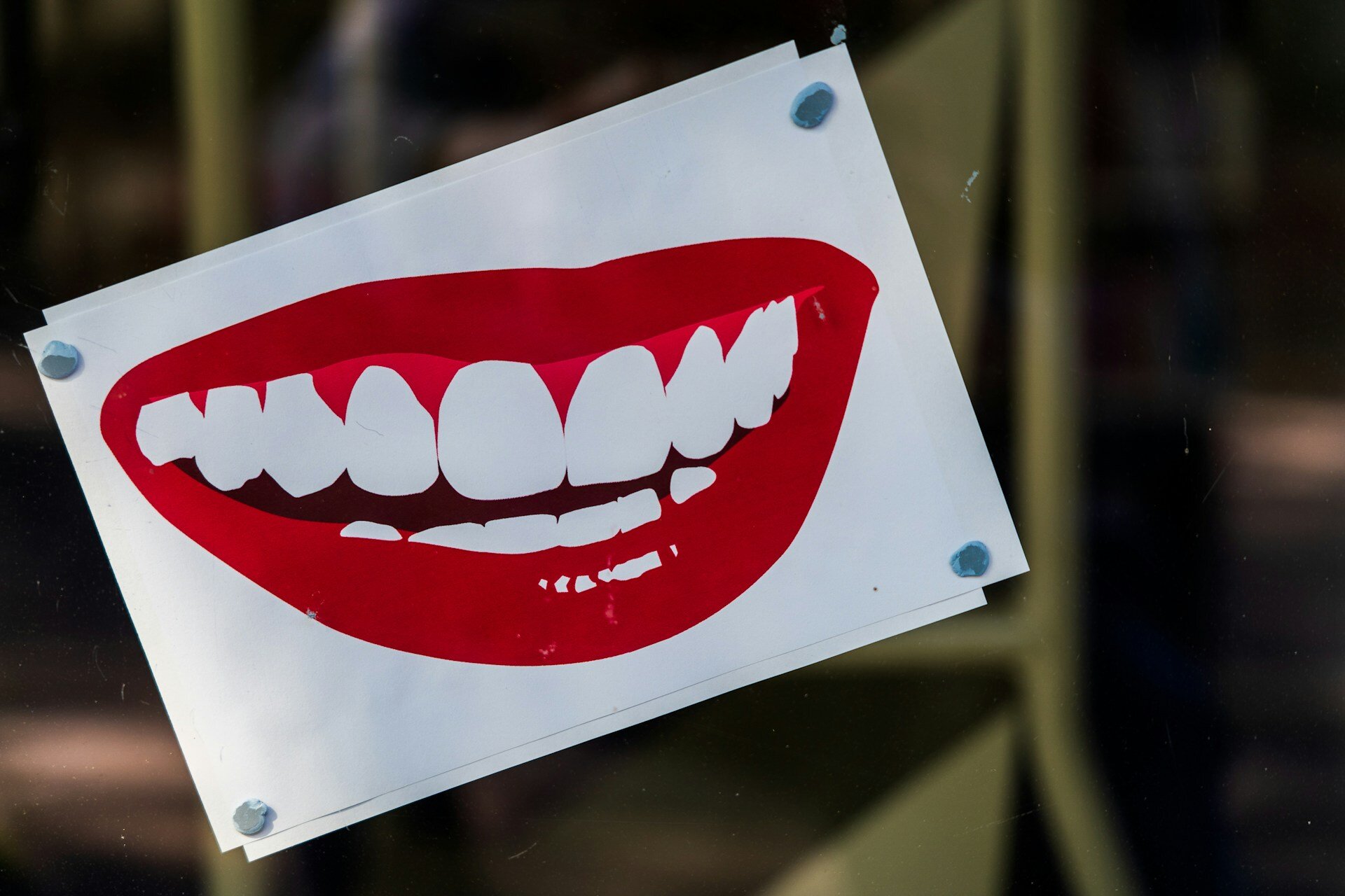 Das Bild zeigt Papier mit einem aufgemalten Mund mit rotem Lippenstift und weißen Zähnen | © Nick Fewings / Unsplash