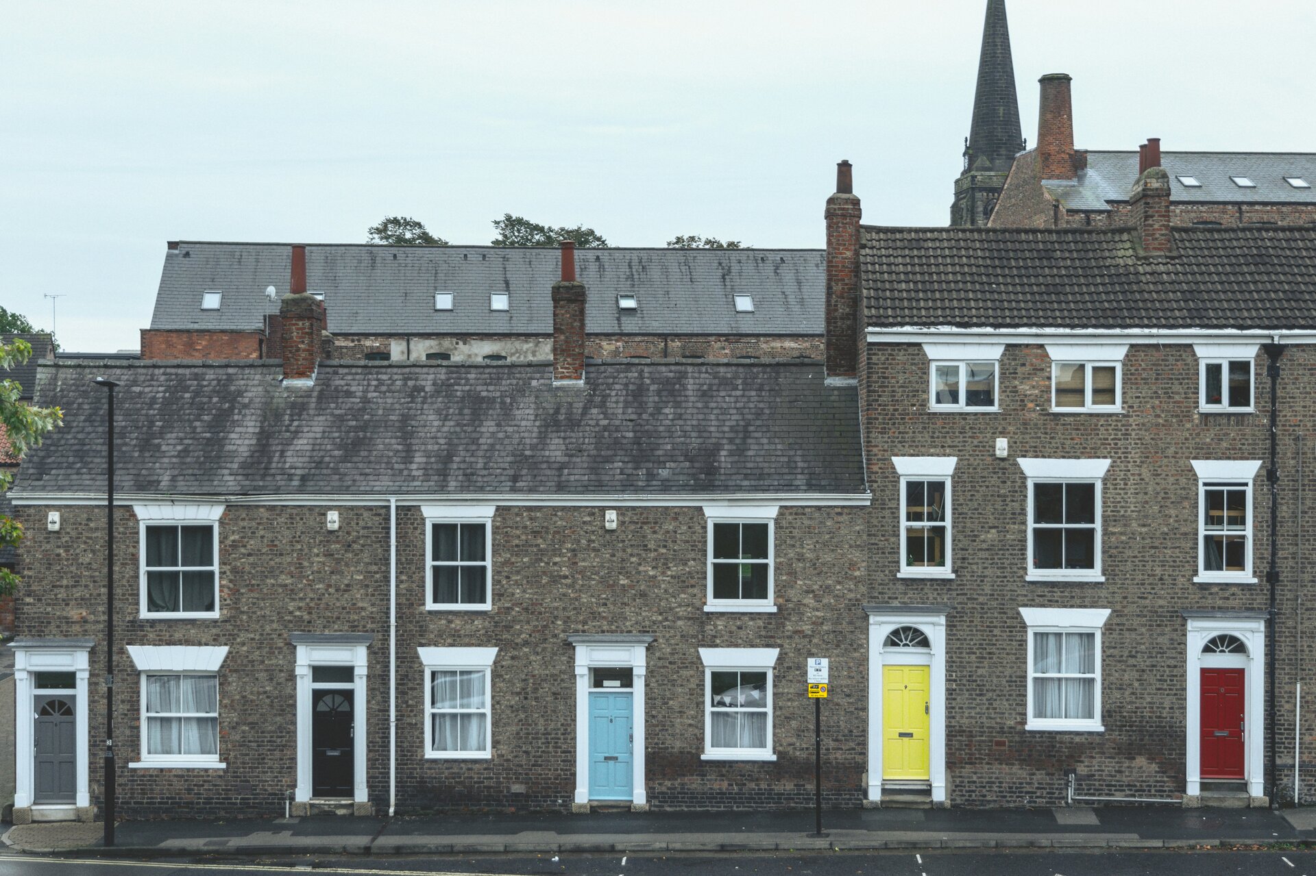 Auf dem Bild sieht man eine Häuserreihe mit farbigen Eingangstüren | © Gonzalo Facello/Unsplash