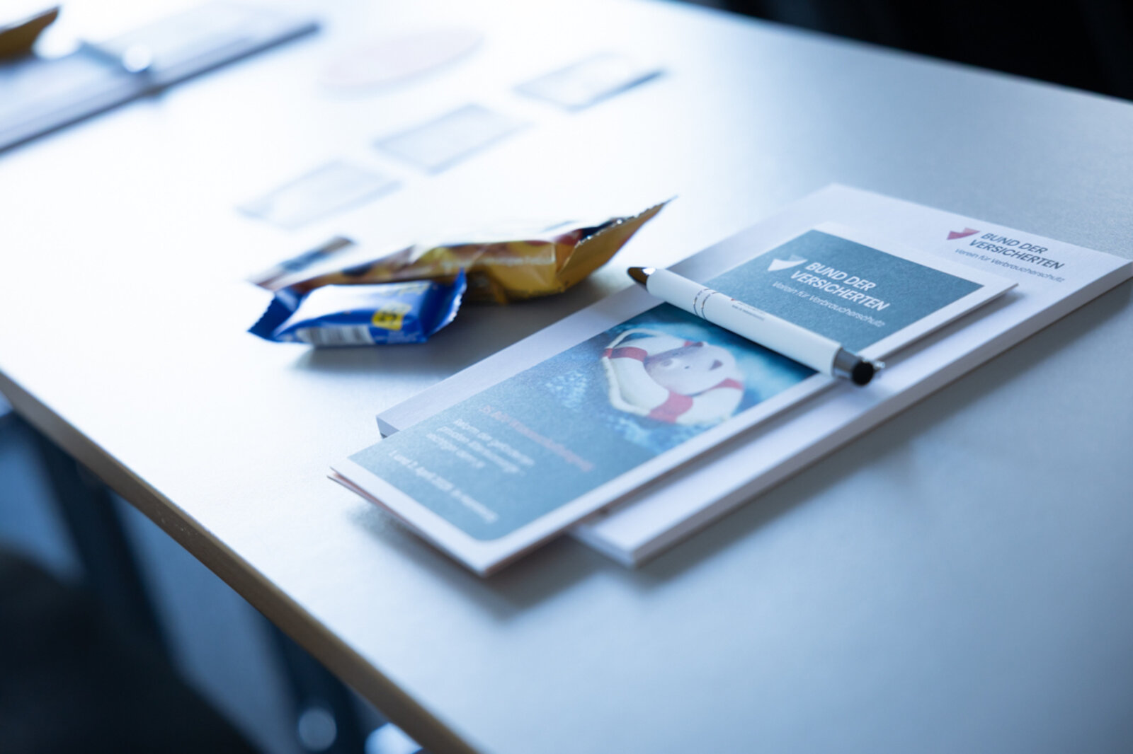 Das Bild zeigt einen Tisch mit Programmflyer, Snacks, Block und Kugelschreiber. | © Valeska Achenbach