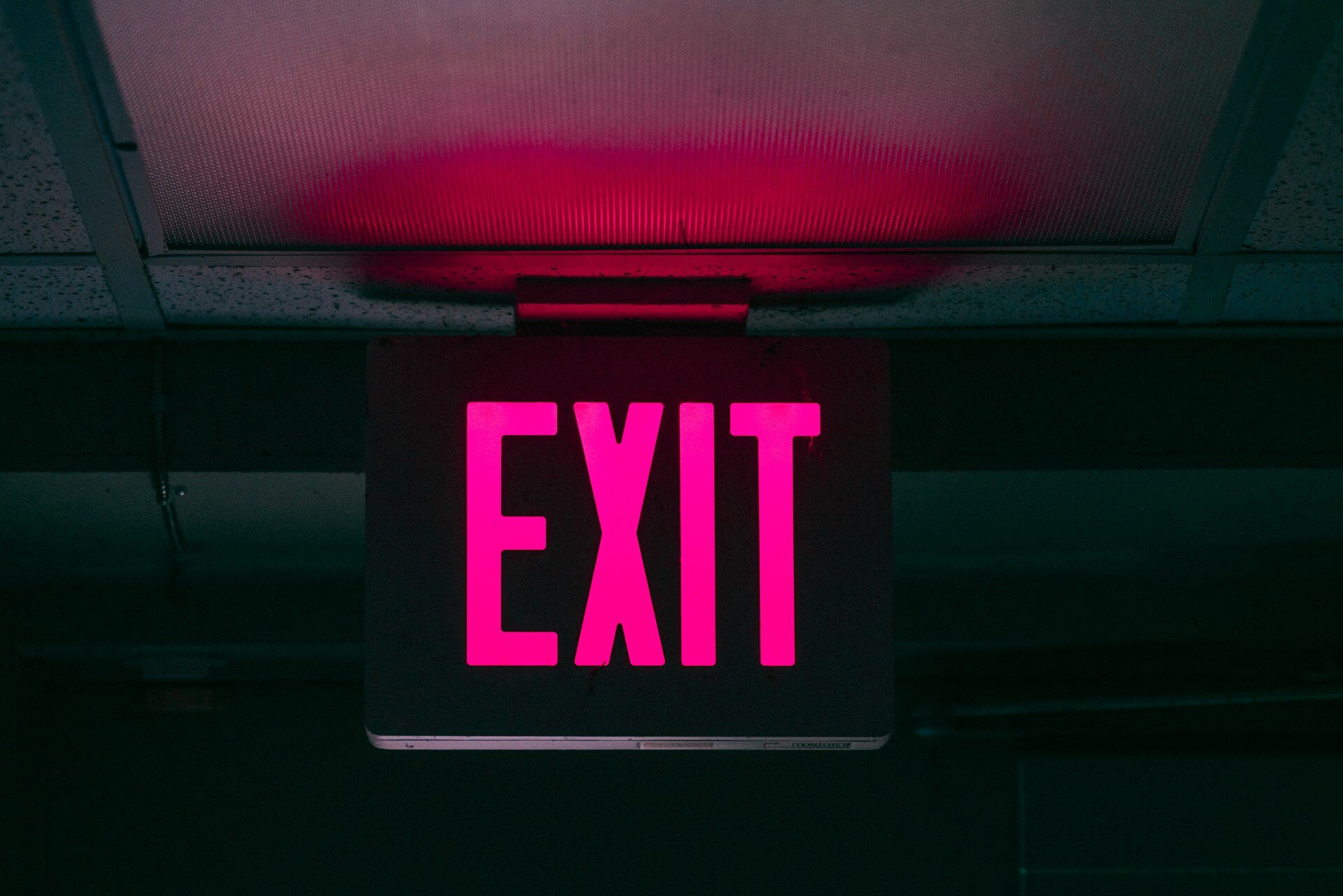 Das Bild zeigt ein pinkes Exit-Schild in einer Unterführung | © Keagan Henman/ Unsplash