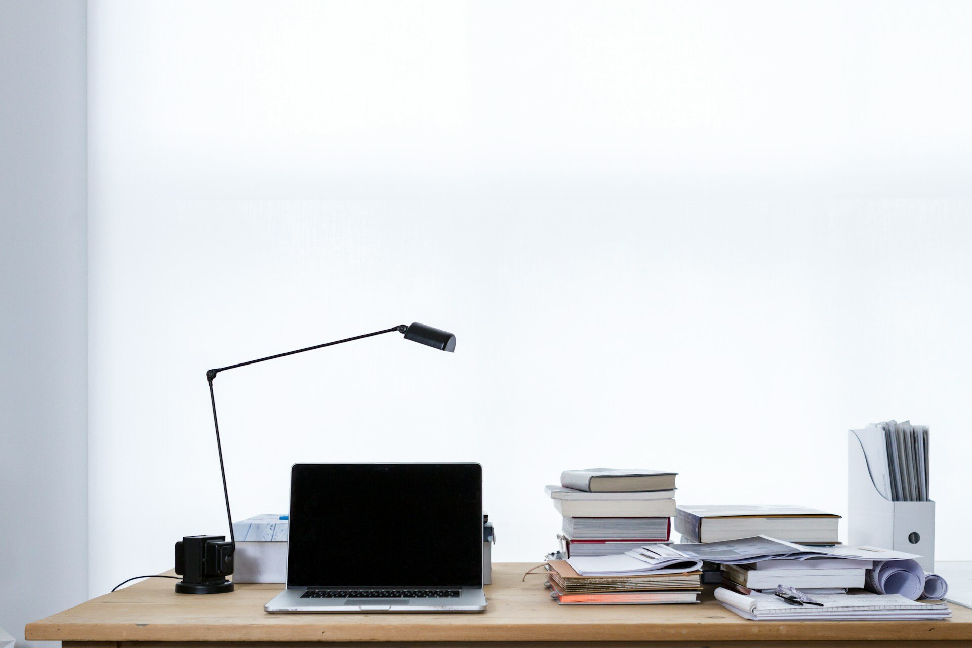 Auf dem Bild sieht  man einen Tisch mit einem Laptop einer Lampe und Büchern | © freddie marriage/Unsplash