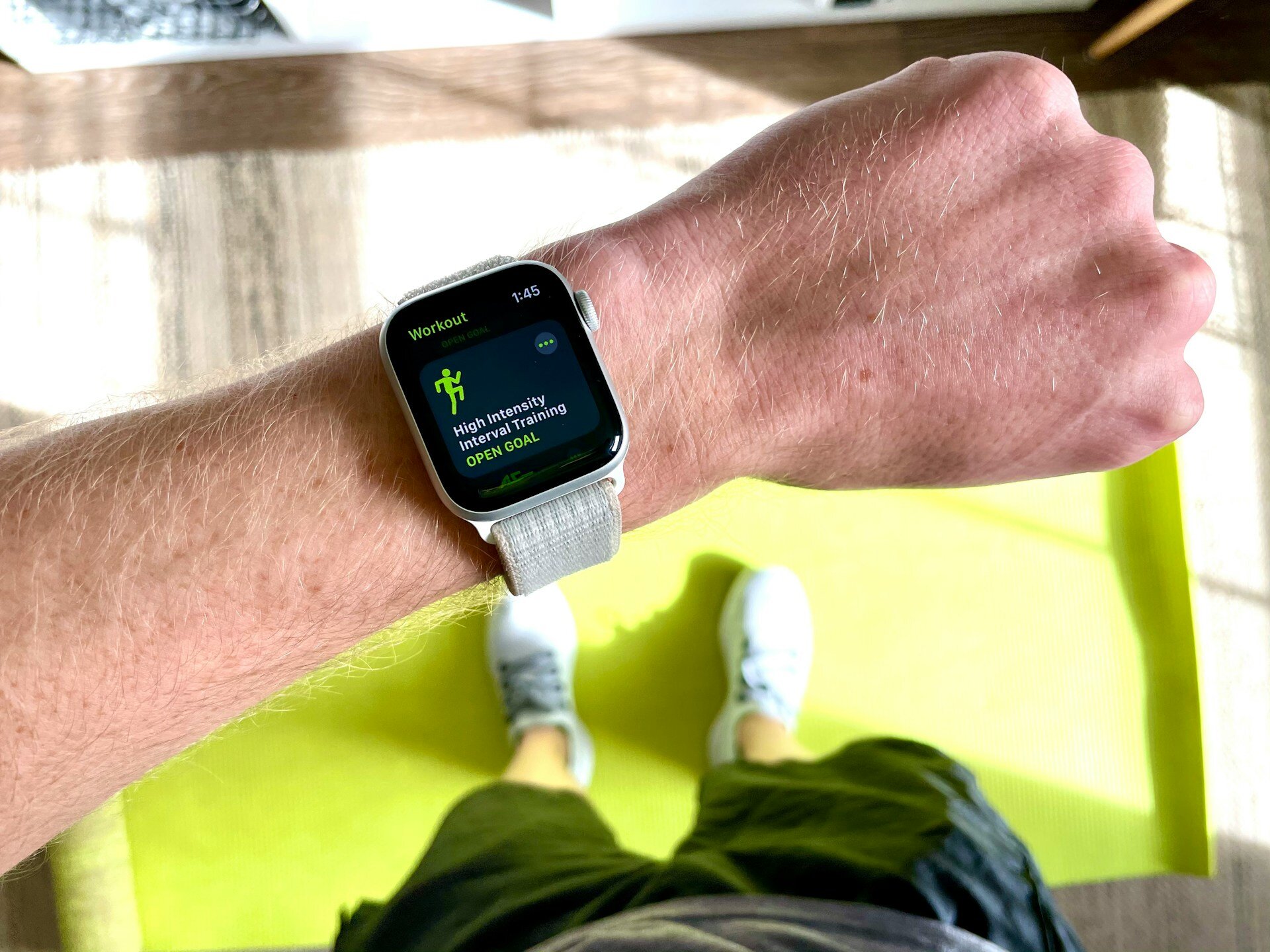 Auf dem Bild sieht man eine Person von oben, die eine Fitnesswatch am Arm trägt und sie in die Kamera hält. Auf der Uhr wird ein Workout angezeigt.  | © Blocks Fletcher / Unsplash