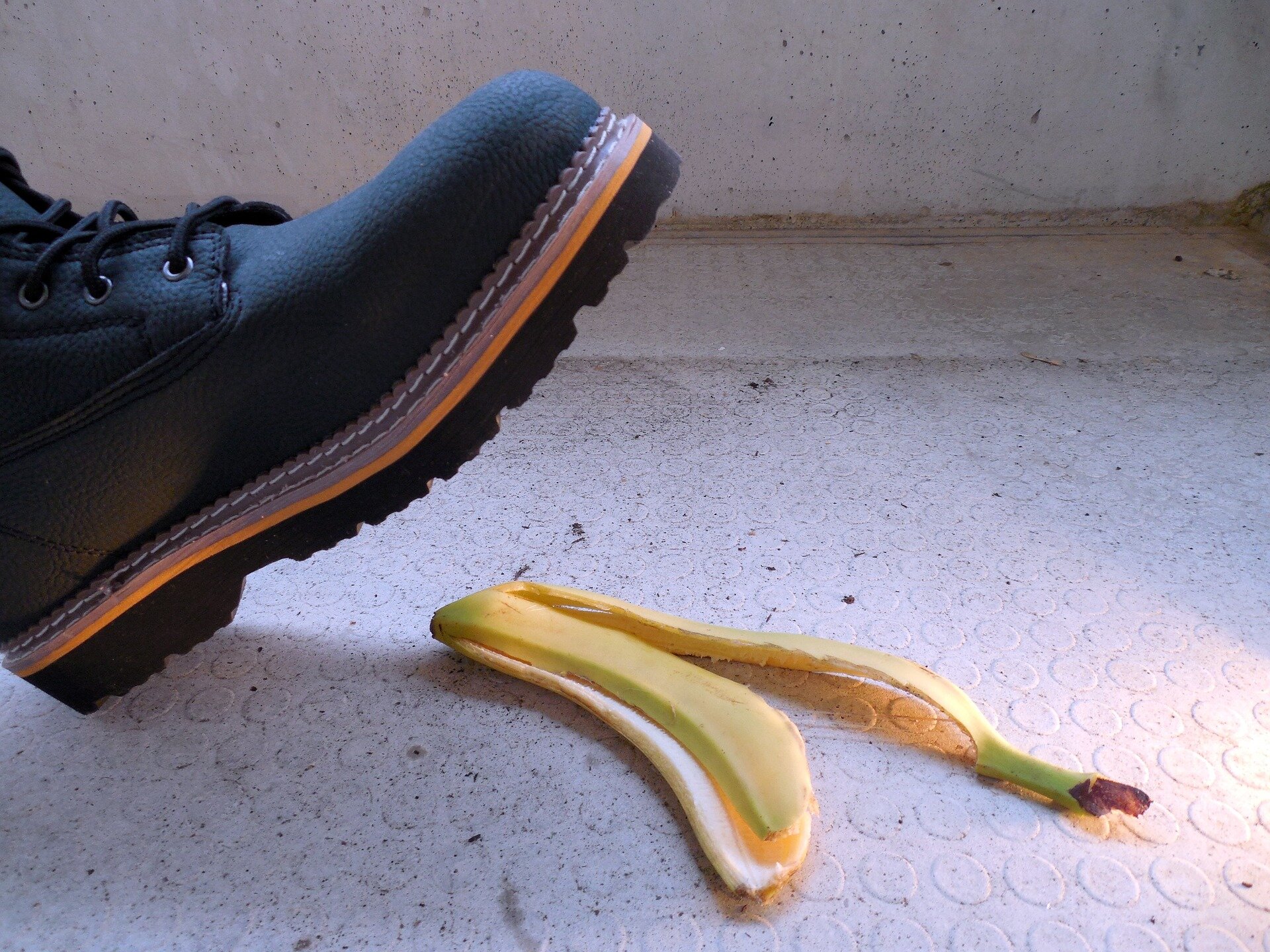 Auf dem Bild sieht man den Schuh einer Person, die dabei ist, auf eine Bananenschale zu treten | © succo / Pixabay