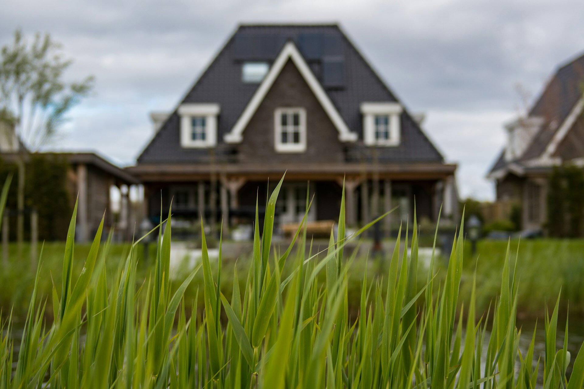 Auf dem Haus sieht man ein verschwommenes Haus. Davor sieht man grünes Gras. | ©  Wynand van Poortvliet/Unsplash